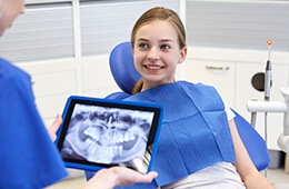 dentist holding x-ray on tablet