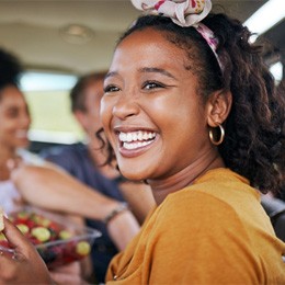 Smiling woman eating meal on road trip