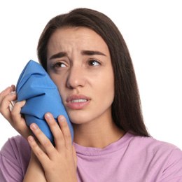 Young woman with a cold compress against her  