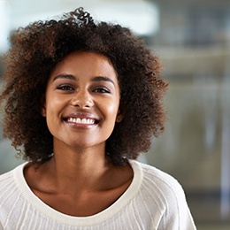 Woman in a white sweater smiling in an office