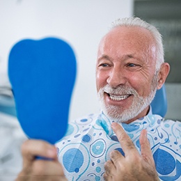 Dental patient checking his smile in a handheld mirror