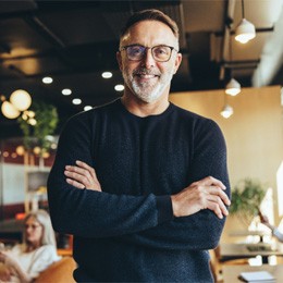 person smiling with his arms crossed