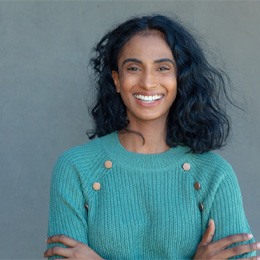 person smiling with their hands on their arms