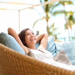 smiling person relaxing on outdoor furniture