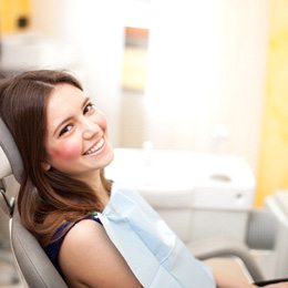 Young woman sitting in dental chair smiling