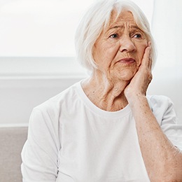 Worried-looking woman rubbing her jaw