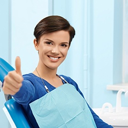 Female dental patient giving a thumbs up