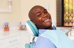 A man smiling in a dental chair.