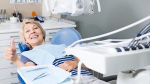 woman with thumbs up in dental chair