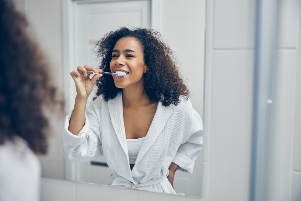 Patient brushing their teeth with veneers