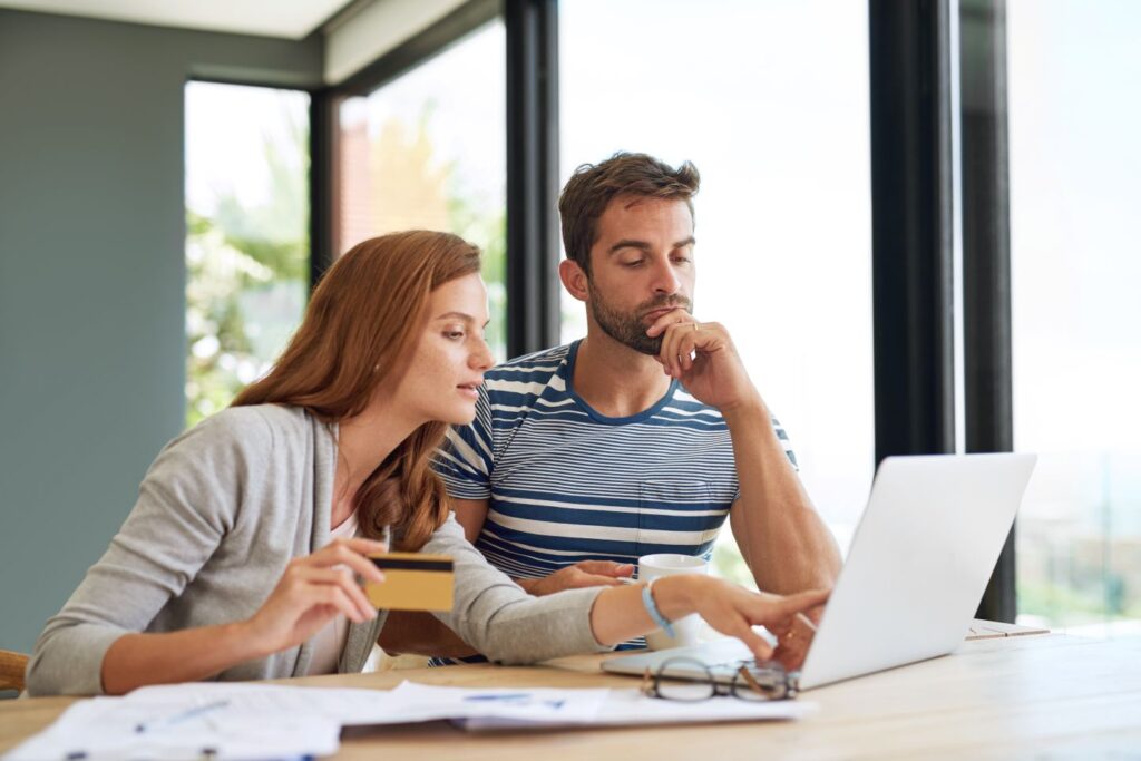 A man and woman looking at a computer together
